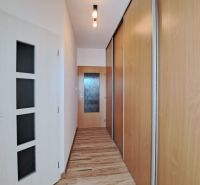 A hallway in a 3-room apartment with a wooden decor floor and built-in wardrobes.