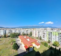 View of the housing estate with a playground, buildings, and mountains in the background in Poprad on Jesenná Street.