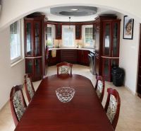 A kitchen in a family house with wooden furniture and a dining table.