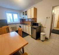 Kitchen in a 2-room apartment with a dining table and appliances.