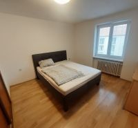 Bedroom with a bed and wooden decor flooring in a two-room apartment.