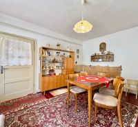 Dining room in a family house with wooden furniture and a red carpet.