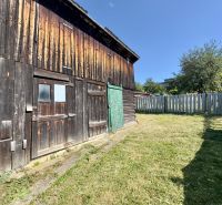Wooden part of a family house in Lipany, fenced garden and woodshed.