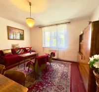A living room in a family house with red furniture and a carpet.