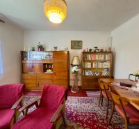 Living room in a family house with a red carpet and wooden furniture.