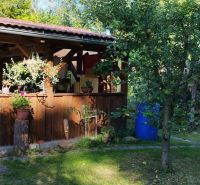 A cottage in Lutila with a wooden terrace, a swinging bench, and surrounding greenery.
