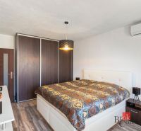 A bathroom in a 2-room apartment with a glass shower enclosure and tiles with a blue pattern.