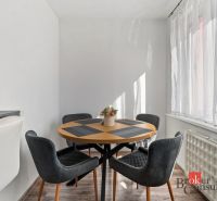 A kitchen in a 2-room apartment with a counter, appliances, and a wooden decor floor.