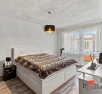 Dining area with a table and chairs in a 2-room apartment with a wooden decor floor.