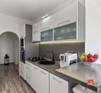 A bright living room in a 2-room apartment with furniture and a TV, floor with a wooden decor.