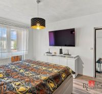 A bedroom with a bed, wardrobe, and wooden decor flooring in a two-room apartment.