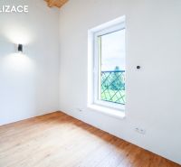 A room in a holiday apartment with a wooden decor floor and a large window.