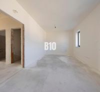 Empty room in a family house with white walls and a concrete floor.
