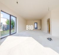 In the family house, there is a bright room with large glazing and access to the garden.