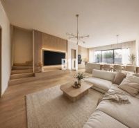 Living room of a family house with a wooden decor floor, light furniture, and large windows.