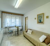 Interior of a family house with a dining room, decorated wall, and simple seating.