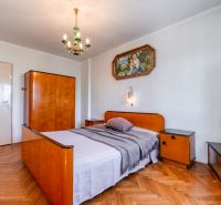 A bedroom in a family house with a wooden decor floor and vintage furniture.