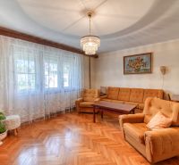 Living room in a family house with a sofa, armchairs, and a wooden decor floor.