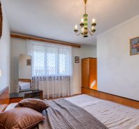 Bedroom with wooden furniture and a chandelier in a family house.