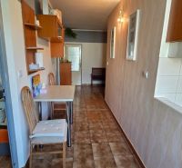 Dining room in a 3-room apartment with a tiled floor and wooden furniture.
