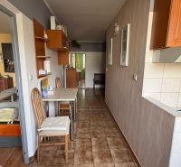 Kitchen corner with a gas stove and dining table in a 3-room apartment.