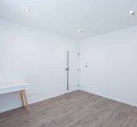 Interior of a family house with white walls, a table, and a wooden decor floor.