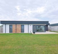 The family house on Milénium Street in Košúty has wooden cladding and a landscaped garden.