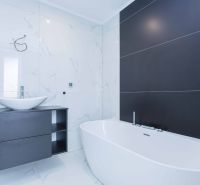 Bathroom in a family house with a bathtub, sink, and white tiles.