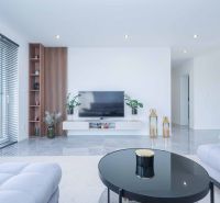 Living room in a family house with a sofa, television, window, and decorative elements.