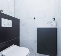 A bathroom in a family house with a toilet and a sink on a marble tile.