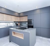 A kitchen in a family house with a kitchen island and gray cabinets.