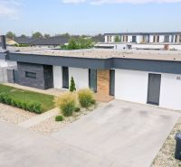 A family house in Košúty on Milénium Street with modern architecture and a landscaped garden.