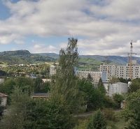 View of the Banská Bystrica skyline from Astrova with apartment buildings and landscape scenery.