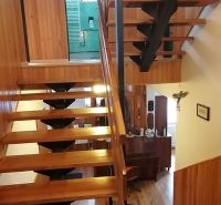 A staircase in a family house with a wooden decor and an open space.