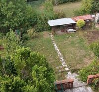 The garden of a family house on Astrová Street in Banská Bystrica with a gazebo and trees.