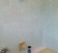 A bathroom in a family house with beige tiles and a bathtub.