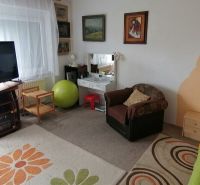 Living room in a family house with a television, carpets, and an armchair.