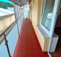 A balcony with tiles and a wooden ceiling, leading from a 3-room apartment.