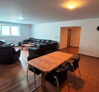 Living room with sofas, a table, a kitchen unit, and a wooden decor floor in a 3-room apartment.