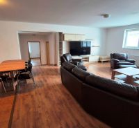 Living room in a three-room apartment with comfortable leather sofas and a floor with a wooden decor.