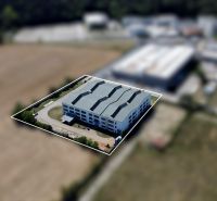 Warehouses and halls on K výstavisku Street in Trenčín, surrounded by greenery and fields.