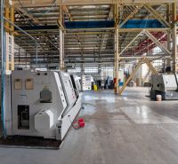 A large hall in a warehouse with industrial machines and a floor with a wooden decor.