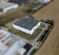 A view of the warehouse in Trenčín on K výstavisku Street, surrounded by a field and a parking lot.