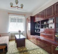 Living room in a family house with a sofa, display cabinet, and carpet.