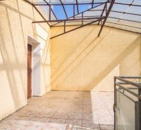 Covered terrace in a family house in Dvory nad Žitavou, with tiles and metal railing.