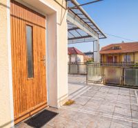 The terrace of a family house in Dvory nad Žitavou with wooden doors and glass railings.