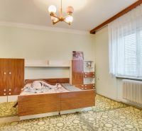 A bedroom with retro furniture in a family house, a floor with a geometric pattern.