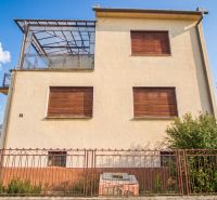 A family house in Dvory nad Žitavou with closed shutters and a glass canopy.