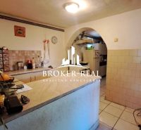 Rustic kitchen with tiled walls and a counter in the cottage.