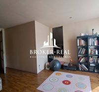Living room in a cottage with a wooden decor floor and a bookshelf.